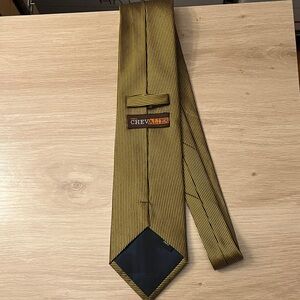 Chevalier Paris necktie with gold vertical stripes and small blue polka dots.